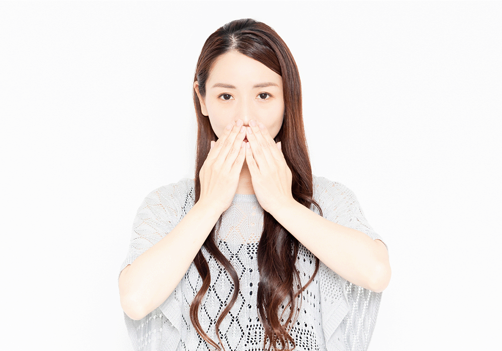 口元に手を当てる女性